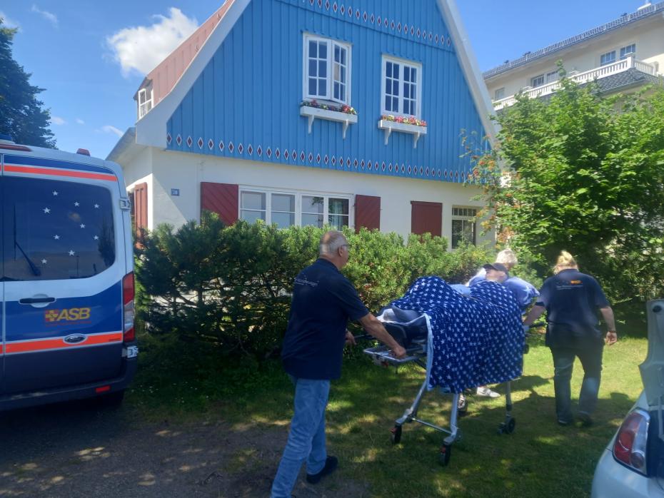 Frank mit Wünschewagen vor dem Sommerhaus